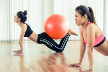 Beden eğitimi dersinde uygun topu ile egzersiz yaparak kadınlar