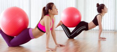 Beden eğitimi dersinde uygun topu ile egzersiz yaparak kadınlar