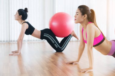 Beden eğitimi dersinde uygun topu ile egzersiz yaparak kadınlar