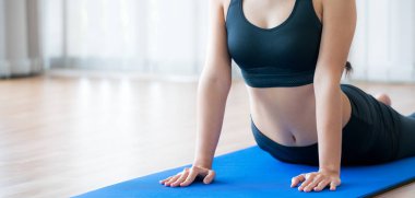 Genç kadın yoga mat kapalı spor salonunda egzersiz