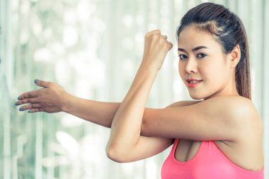 Sportif kadın kol germe yapıyor