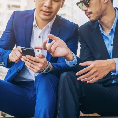 İki iş adamları iş ilişkisi cep telefonu üzerinde tartışmak.