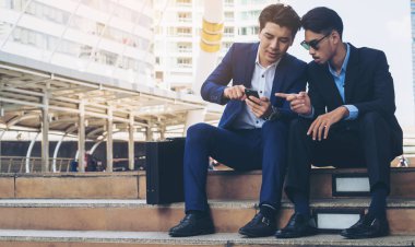 İki iş adamları iş ilişkisi cep telefonu üzerinde tartışmak.