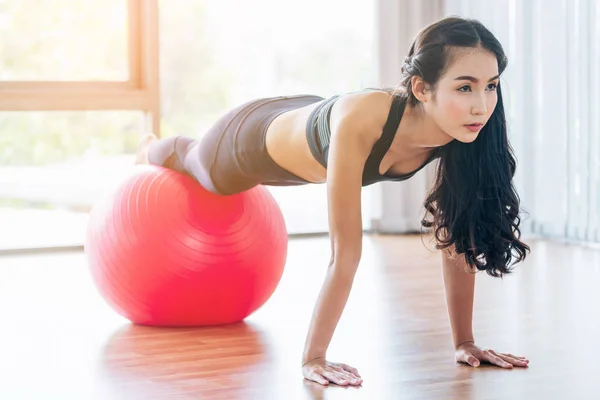 Женщина делает упражнения с мячом в фитнес-зале — стоковое фото