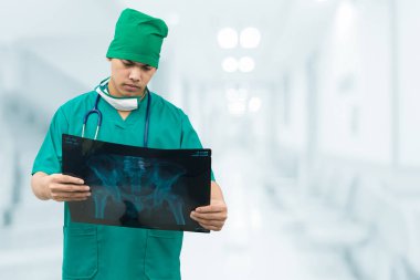 Surgical doctor looking at x-ray film. clipart