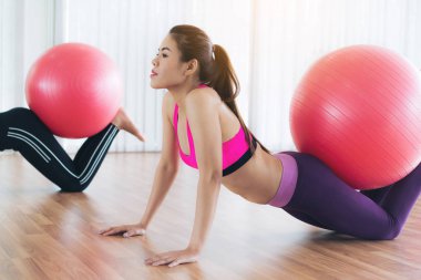 Beden eğitimi dersinde uygun topu ile egzersiz yaparak kadınlar