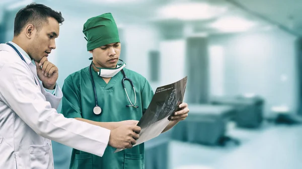 Médico y cirujano mirando la radiografía — Foto de Stock