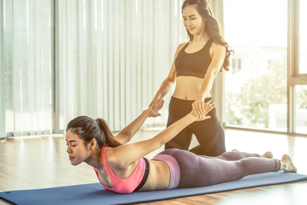 Tränare hjälpa kvinnan på kroppen stretching — Stockfoto