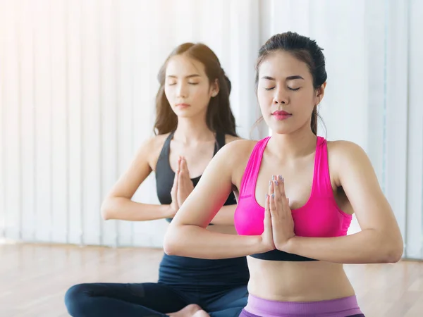Женщины практикующие йогу позируют в тренажерном зале — стоковое фото