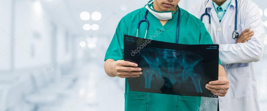 Surgeon and doctor looking at x-ray film.