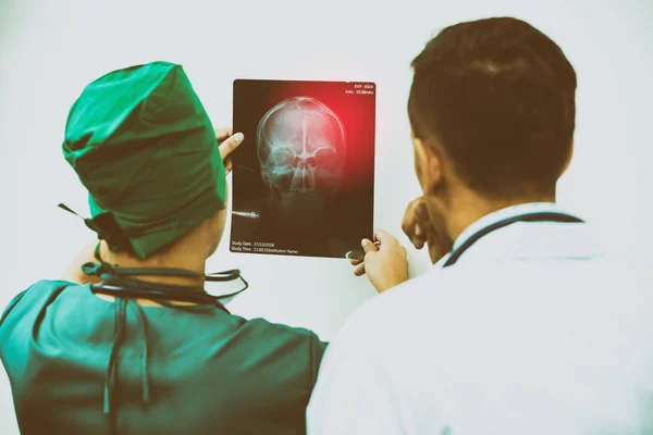 Médicos mirando la radiografía de la cabeza del paciente — Foto de Stock