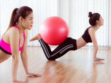 Beden eğitimi dersinde uygun topu ile egzersiz yaparak kadınlar