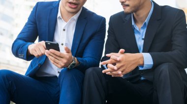 İki iş adamları iş ilişkisi cep telefonu üzerinde tartışmak.