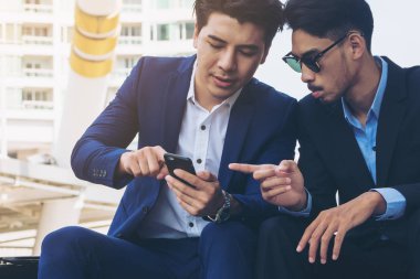 İki iş adamları iş ilişkisi cep telefonu üzerinde tartışmak.