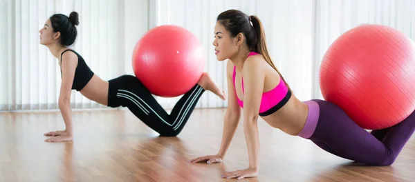 Mujeres haciendo ejercicio con la pelota en forma en la clase de gimnasia —  Fotos de Stock