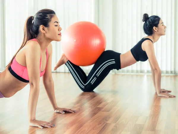 Женщины делают упражнения с мячом в спортзале — стоковое фото