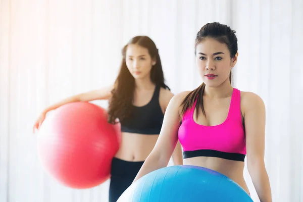 Femmes tenant le ballon de remise en forme dans la salle de gym classe de groupe — Photo