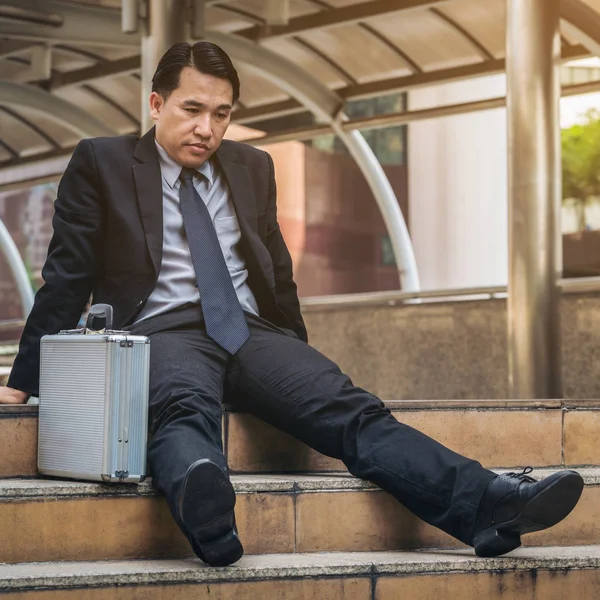 Empresário desesperado sentado desesperadamente no chão da escada — Fotografia de Stock