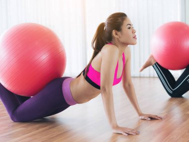 Beden eğitimi dersinde uygun topu ile egzersiz yaparak kadınlar