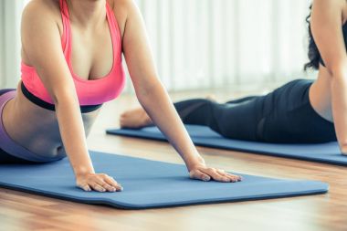 Yapıyor kadın fitness salonunda yoga esneme arka