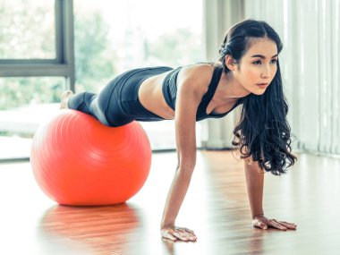 Kadın fitness salonunda uygun topu ile yapıyor