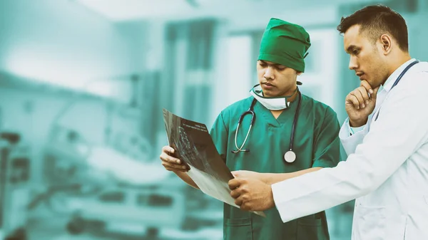 Médico y cirujano mirando la radiografía — Foto de Stock