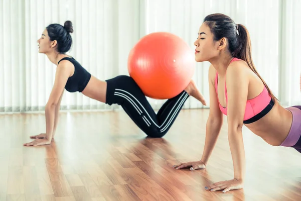 Женщины делают упражнения с мячом в спортзале — стоковое фото