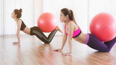 Beden eğitimi dersinde uygun topu ile egzersiz yaparak kadınlar