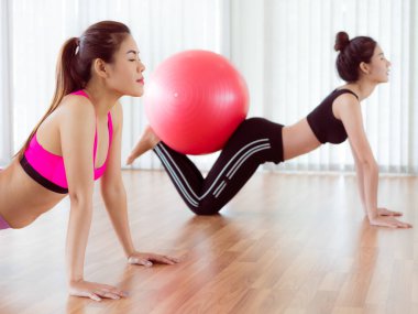 Beden eğitimi dersinde uygun topu ile egzersiz yaparak kadınlar