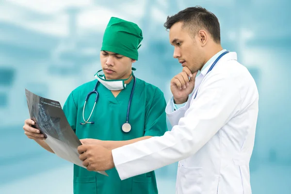 Médico y cirujano mirando la radiografía — Foto de Stock