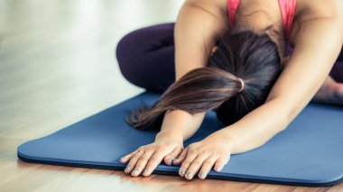 Kadın pratik yoga teşkil spor salonunda