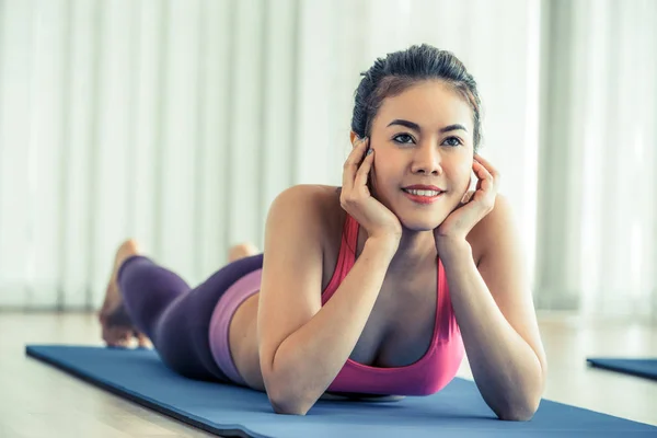 年轻快乐的女人躺在上，在健身房瑜伽垫上 — 图库照片