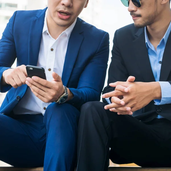 Two business people discuss business affair on mobile phone