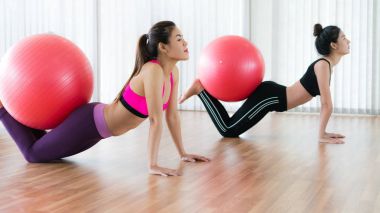 Beden eğitimi dersinde uygun topu ile egzersiz yaparak kadınlar