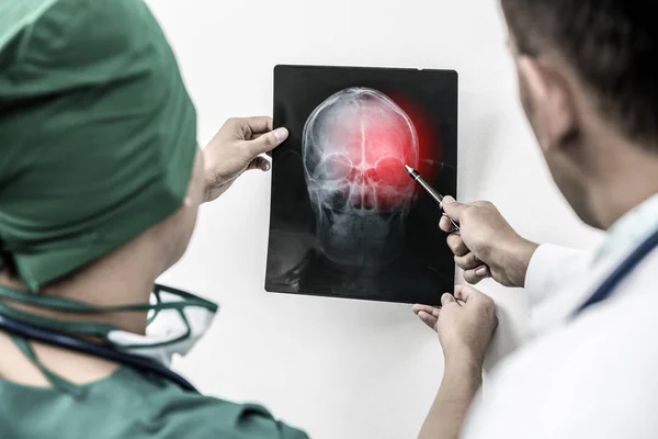 Lekarze, patrząc na RTG głowy pacjenta — Zdjęcie stockowe