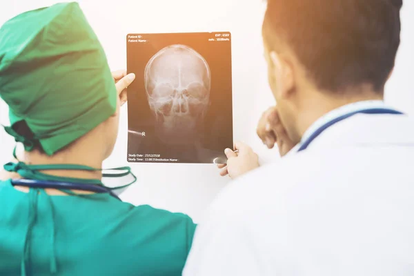 Médicos mirando la radiografía de la cabeza del paciente — Foto de Stock