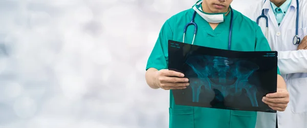 Cirujano y médico mirando la película de rayos X . — Foto de Stock