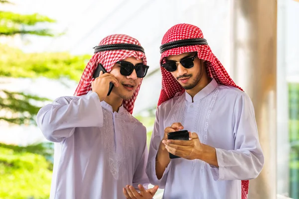 Hombres árabes hablando y usando teléfono móvil — Foto de Stock