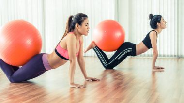 Beden eğitimi dersinde uygun topu ile egzersiz yaparak kadınlar