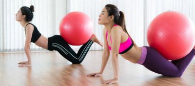 Beden eğitimi dersinde uygun topu ile egzersiz yaparak kadınlar