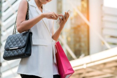 Alışveriş çantası istimal hareket eden telefon ile mutlu kadın