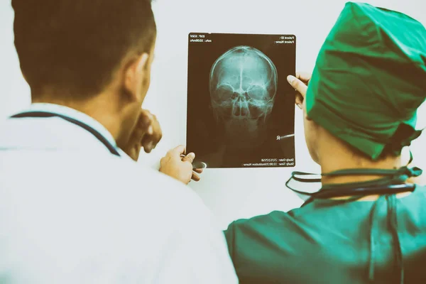 Médicos mirando la radiografía de la cabeza del paciente — Foto de Stock