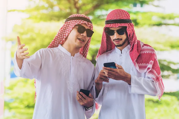 Hombres árabes hablando y usando teléfono móvil — Foto de Stock