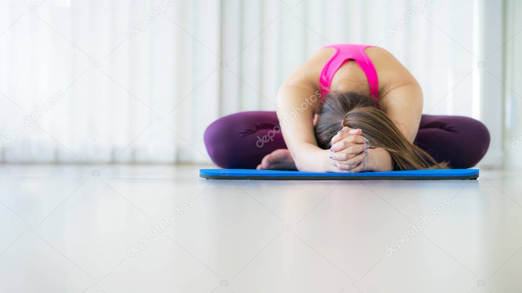 Young woman exercising stretching back yoga pose