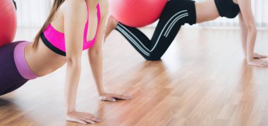 Beden eğitimi dersinde uygun topu ile egzersiz yaparak kadınlar