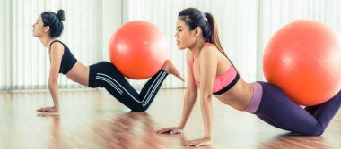 Beden eğitimi dersinde uygun topu ile egzersiz yaparak kadınlar