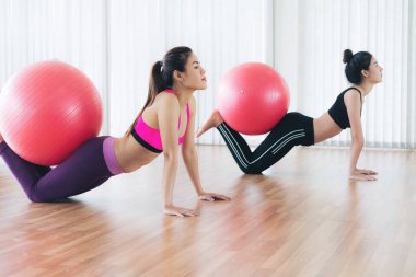 Beden eğitimi dersinde uygun topu ile egzersiz yaparak kadınlar