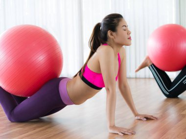 Beden eğitimi dersinde uygun topu ile egzersiz yaparak kadınlar