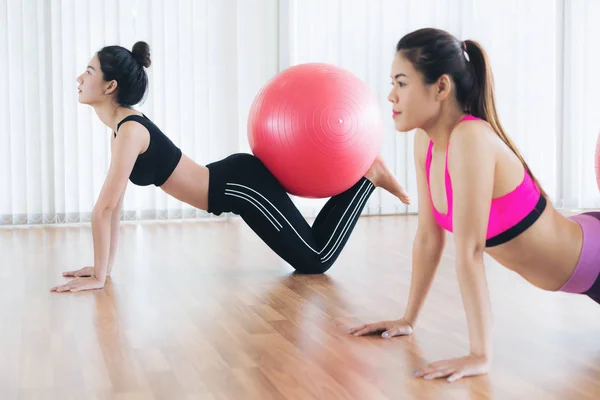 Mujeres haciendo ejercicio con la pelota en forma en la clase de gimnasia —  Fotos de Stock