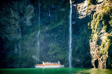 Manzaralı gemi şelaleye yaklaşıyor, Milford Sound..